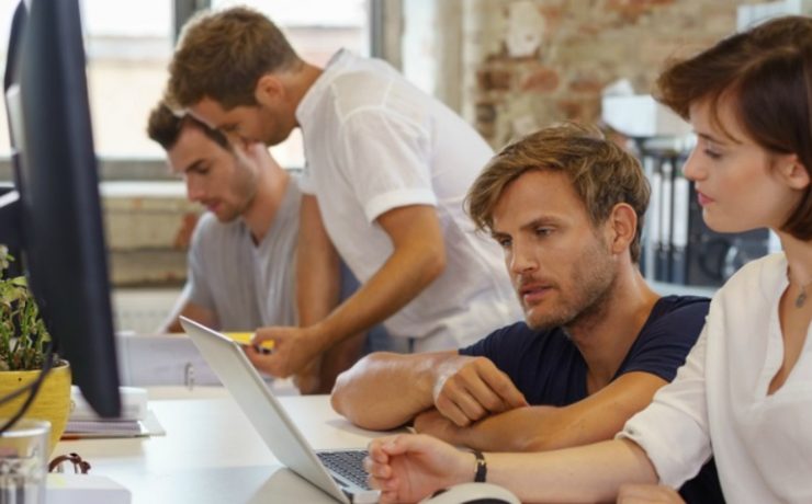 Two people sitting at a computer getting ready to print