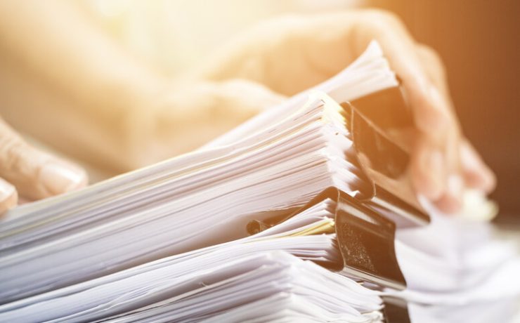 person holding stack of papers