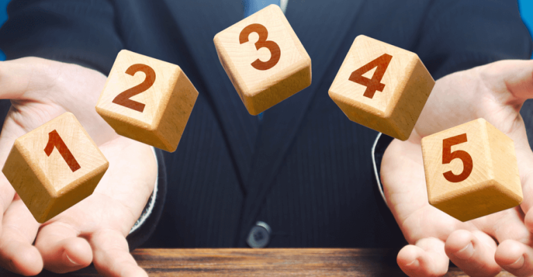 Man holding five blocks with number on each block.