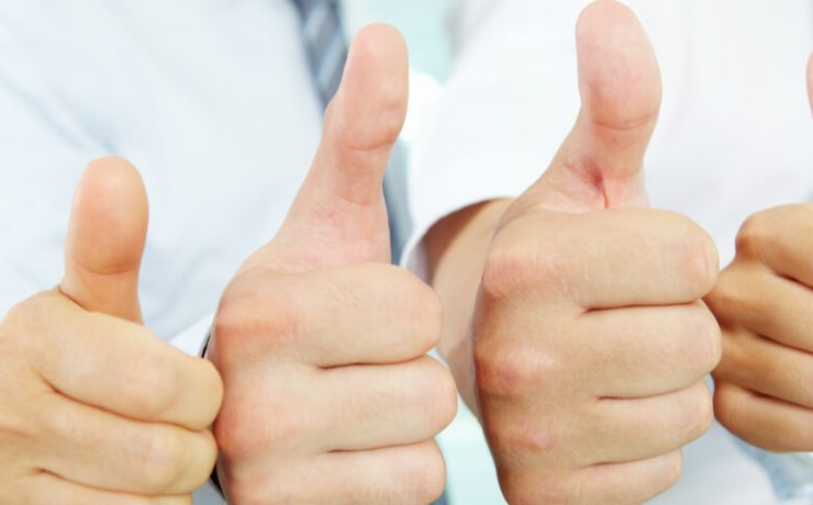 Close up of four hands in a row giving the thumbs up