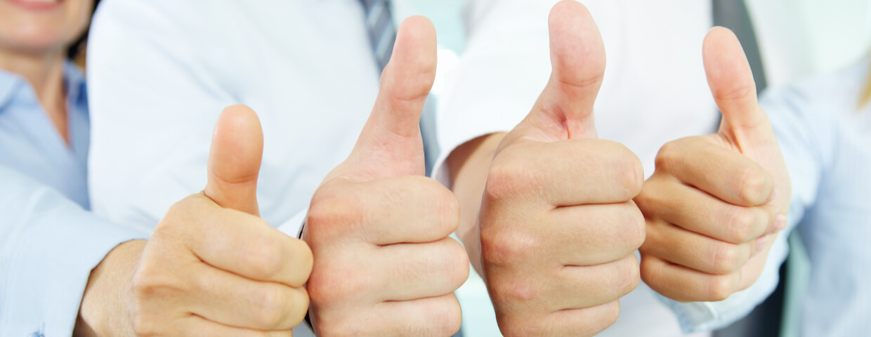 Close up of four hands in a row giving the thumbs up