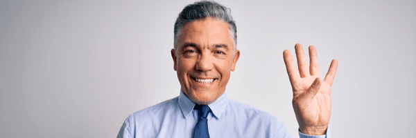 Smiling businessman holding up his hand with four fingers